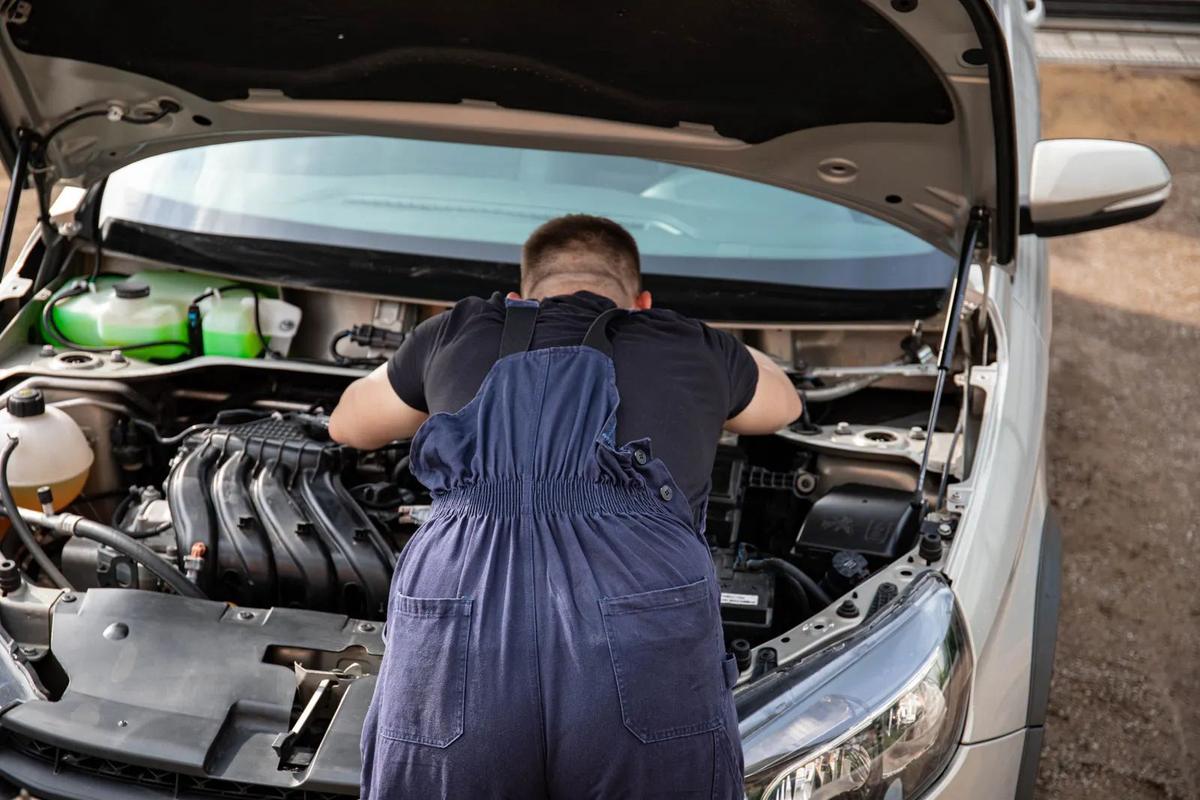 Technician working under the hood in the service bay
